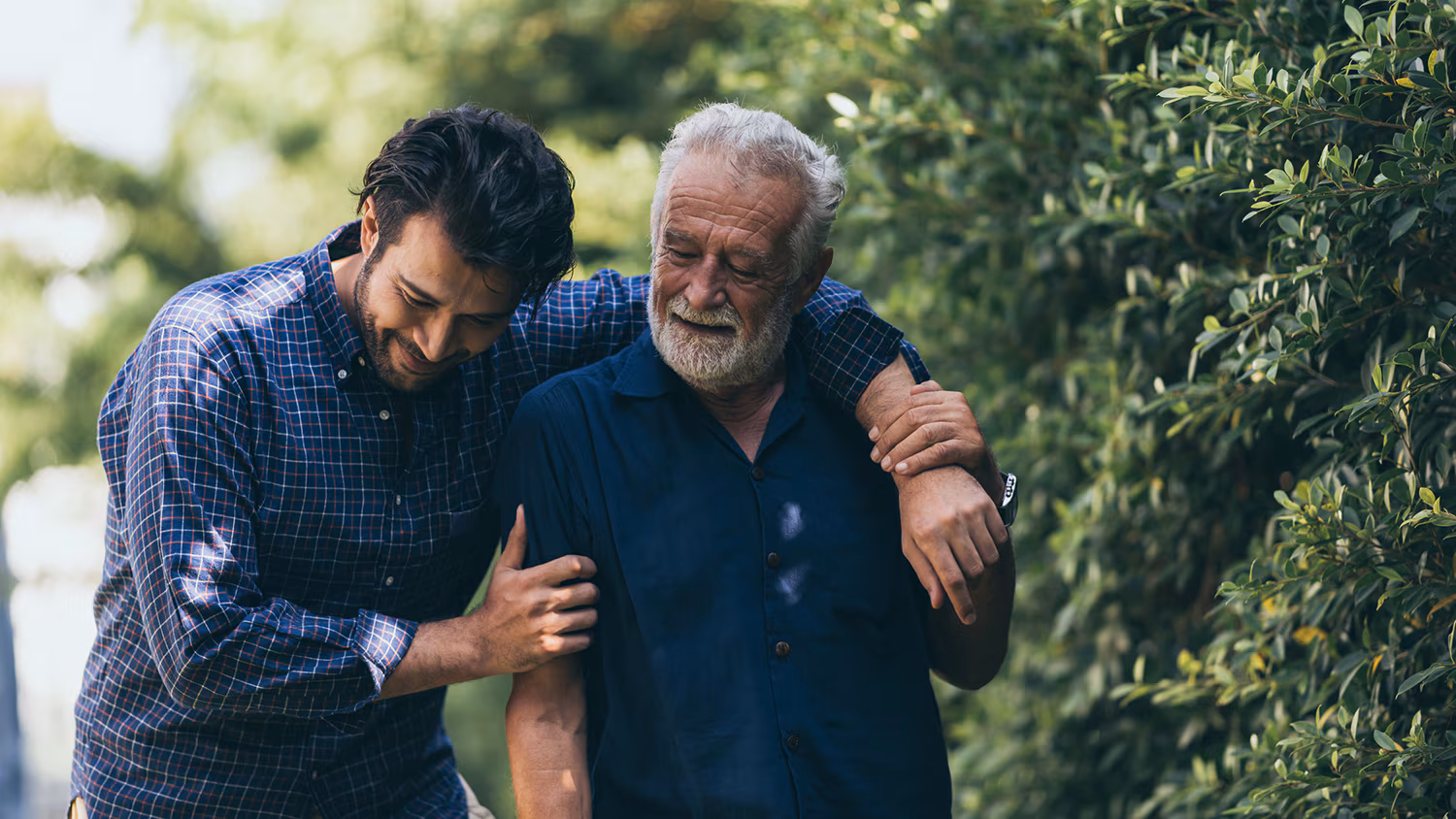 The old man and his son are walking in the park. A man hugs… The old man and his son are walking in the park. A man hugs…