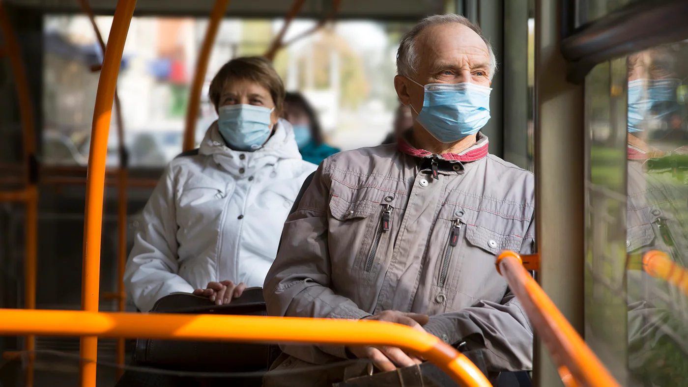 Senior man wearing medical face mask sitting in the bus tran… Senior man wearing medical face mask sitting in the bus