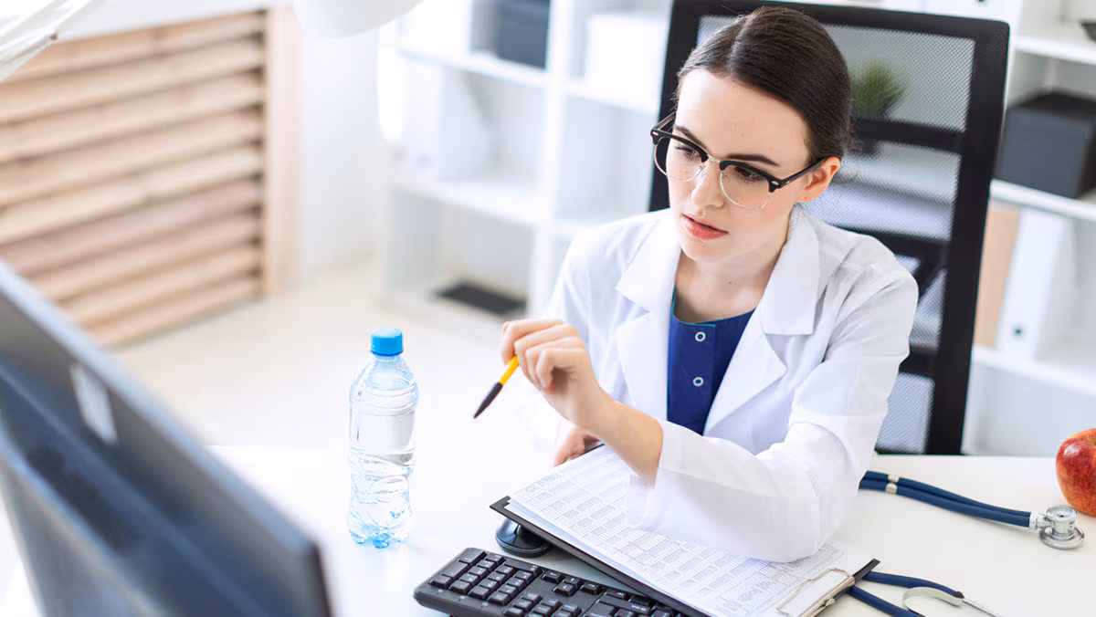 Health care provider seated at computer Health care provider working on a computer.