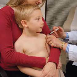 Mom holds older child Mom with child during vaccination
