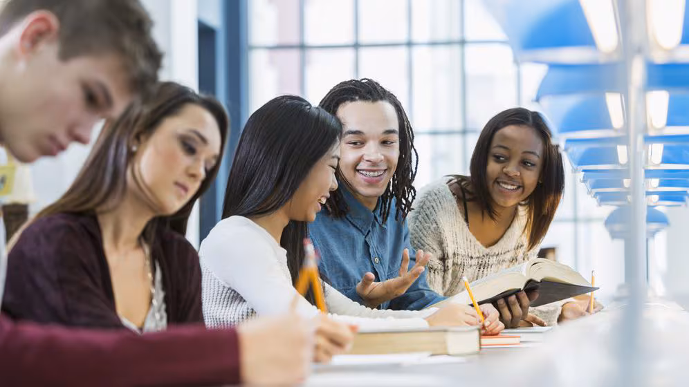 High school students sitting and talking in the library.